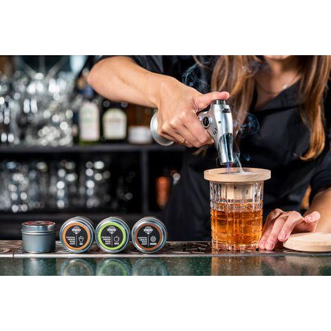 cocktailsavustin käytössä, baarimikko käyttää savustinta maustaakseen drinkin