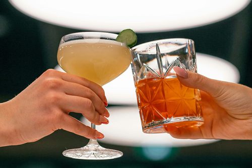 viski sour ja limoncello spirtz, ihmiset skoolaavat ja lasit kohtaavat